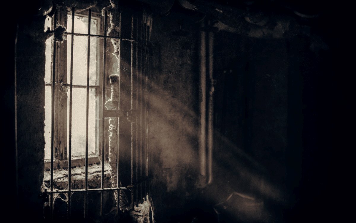Věznění, mříž, okno, paprsek světla, tma / Photo by Denny Müller on Unsplash